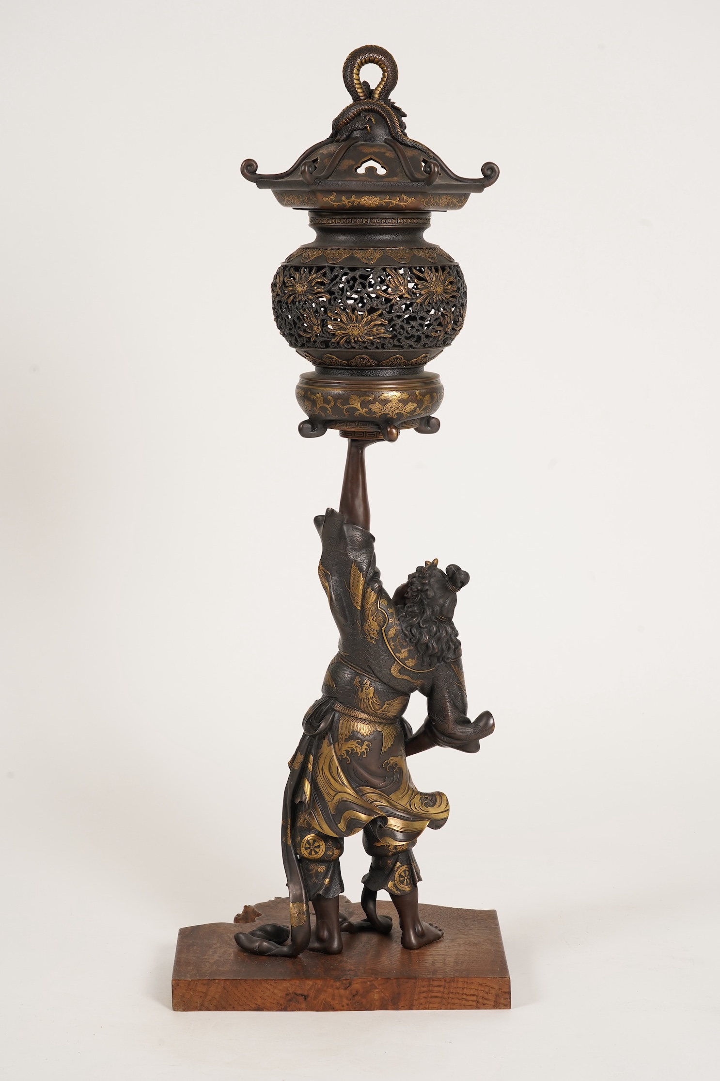 A large Japanese Miyao style parcel gilt bronze figure holding a koro aloft, 20th century